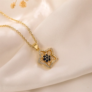 Detail of gold floral pendant necklace with blue sapphire stone and white cubic zirconia