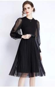 Elegant black knit dress with polka dot mesh sleeves and a pleated skirt details