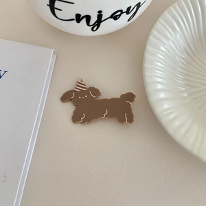 Detailed view of a cute brown puppy acrylic hair clip with a striped birthday hat