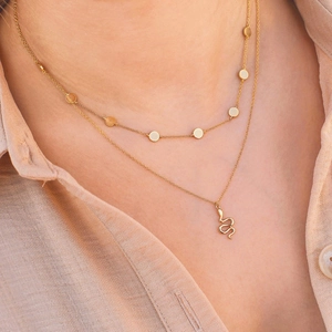 Gold layered necklace featuring round sequins and a detailed creative snake pendant