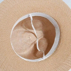 Detail view of the straw sun hat interior showing the sweatband and elastic chin strap
