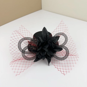 Detail of red mesh veil and black fabric floral fascinator for vintage costumes