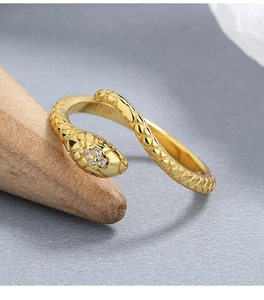 Macro shot of gold snake ring showing scales, green gem eyes and S925 silver hallmark