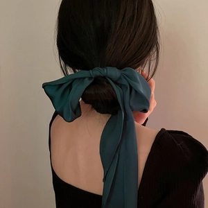 Elegant dark green silk satin bow hair tie ribbon shown on a low bun hairstyle
