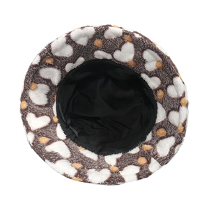 Plush bucket hat with brown and orange heart pattern on soft white faux fur texture
