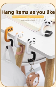Detail of cute panda and cat desk hooks for hanging backpacks on table edges