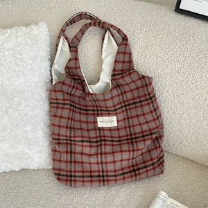 Detail of vintage wool plaid tote bag showing fabric texture and woven brand label
