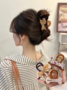 Detail of cartoon puppy and bone shaped hair claw clips made of glossy acetate resin