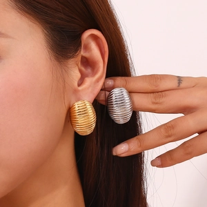 Detailed comparison of gold and silver textured oval J-shape earrings on ear