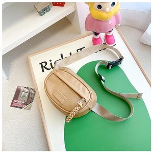 Detail view of khaki nylon kids waist bag with adjustable strap and TOCHASO leather patch