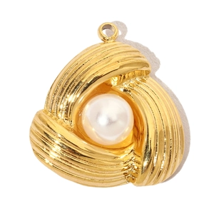 Macro detail of French vintage gold spiral pendant featuring a white pearl inlay