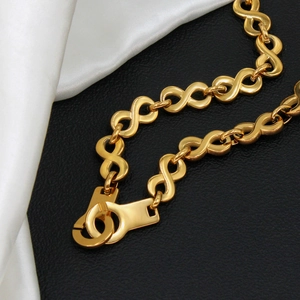 Polished 18K gold stainless steel infinity link necklace on silk and leather background