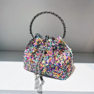 Close-up of colorful rhinestone bucket bag with silver metal ring handle and tassels
