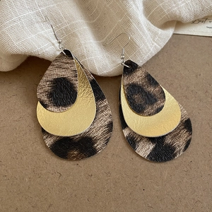 Detail of layered teardrop earrings with leopard print and golden faux leather texture
