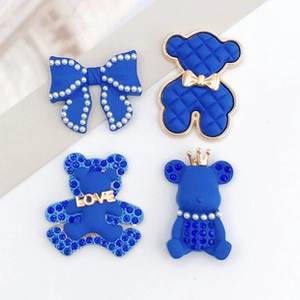 Detail of four blue and gold teddy bear charms with pearls, rhinestones and LOVE tag