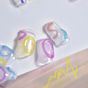 Detail of clear press-on nails featuring 3D macaron color spiral jelly swirls and glossy finish