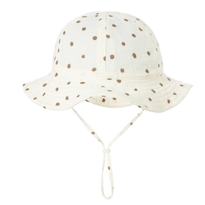 Detail of baby cotton gauze sun hat featuring brown polka dots and adjustable chin strap