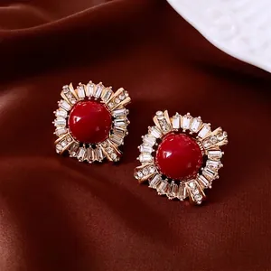 Vintage style red zircon stud earrings with golden finish in a sunburst design