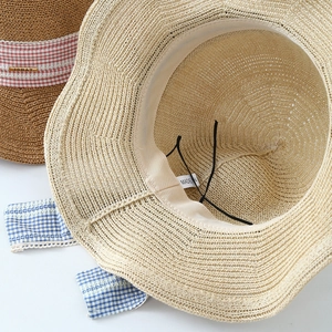 Detail view of woven sun hat showing sweatband, adjustable drawstring and straw texture