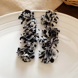 Detail of floral fabric drop earrings with leopard print and golden metal hooks
