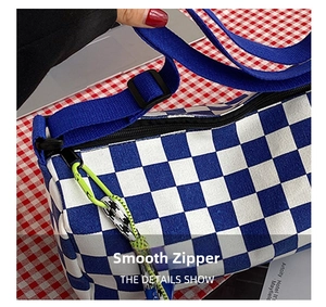 Detail shot of blue checkerboard canvas bag with smooth zipper and neon green carabiner