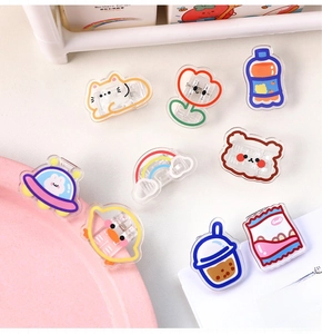 Detailed macro view of colorful cartoon acrylic clips in cat and flower shapes on a desk