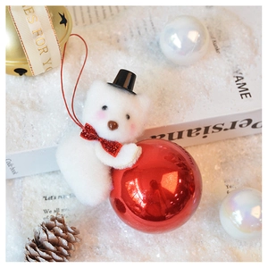 Close-up of plush white bear ornament with red glitter bow and glossy red Christmas ball