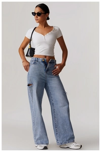 Close-up of a white V-neck ribbed yoga T-shirt paired with blue distressed denim jeans