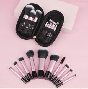 Mini 10pcs pink makeup brush set with black mesh travel bag on a soft pink background