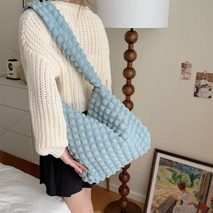 Detailed view of light blue popcorn textured fabric tote bag worn with a casual outfit