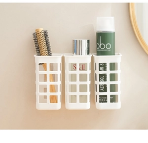 Close-up of wall-mounted hollow storage baskets for hair tools and toiletries