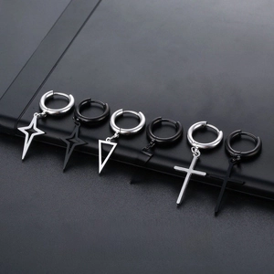 Macro detail of stainless steel earring charms in cross, triangle and star shapes