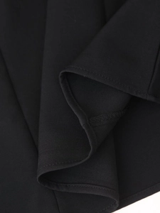 Close-up macro view of the black chiffon fabric texture and stitching detail of the dress