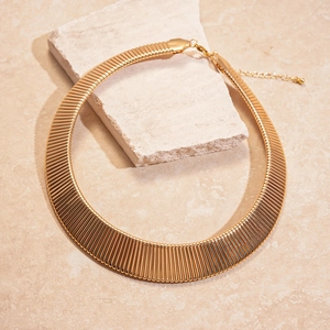 Detailed view of bold golden wide collar necklace with textured links and lobster clasp