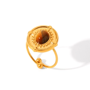 Macro di un anello vintage dorato con pietra occhio di tigre naturale e dettagli