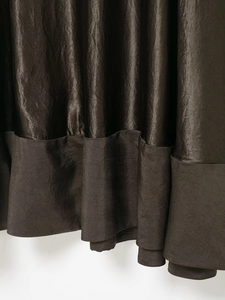 Gros plan sur le tissu en satin bronze à texture plissée et finition éclat métallique