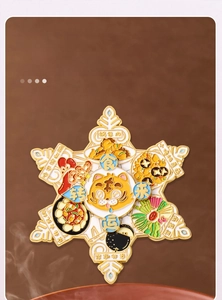 Close-up of rotating metal fridge magnet featuring a cartoon tiger and enamel food icons