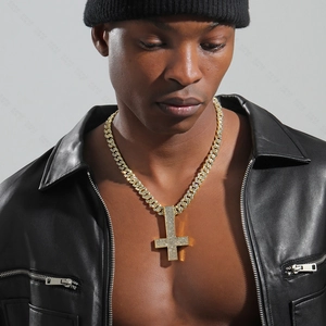 Close-up of luxury gold-tone inverted cross necklace with crystals on a male model