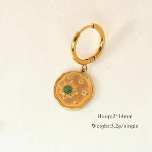 Makroaufnahme von 14K vergoldeter Creole mit Sonnenmünze und grünem Edelstein-Detail