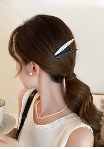 Détail d'une pince à cheveux de luxe en acrylique avec strass sur une queue-de-cheval
