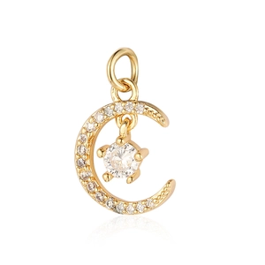 Macro detail of a gold crescent moon and star pendant with cubic zirconia inlay