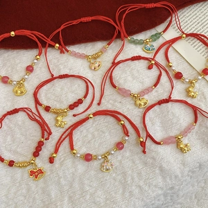 Vue macro détaillée de bracelets en corde rouge avec pendentifs de cheval dorés