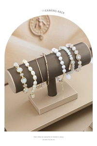 Detail view of T-bar jewelry display stands with pearl and gold metal bracelets