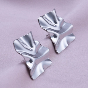 Detail shot of silver irregular wrinkled 304 stainless steel stud earrings on purple fabric