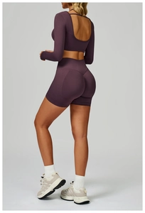 Detail of deep purple ribbed yoga set showing U-shaped backless top and high-waisted shorts