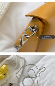 Detail of silver metal lobster clasp and rhinestone accent on yellow leather handbag
