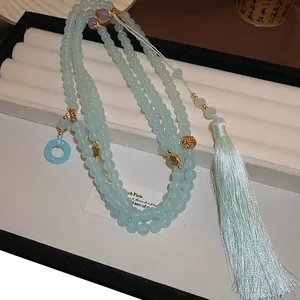 Pale blue glass beaded necklace with gold metal Fu Shou charms and a long tassel