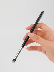 Detail of soft synthetic fiber brush head with black matte handle and silver ferrule