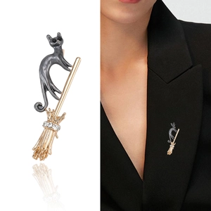 Fashionable flying broom cat brooch with rhinestones shown on black suit lapel