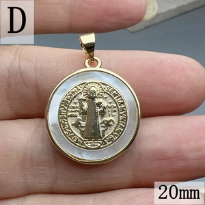 Vista macro di un ciondolo medaglia religiosa dorata da 20mm con inserto in madreperla bianca